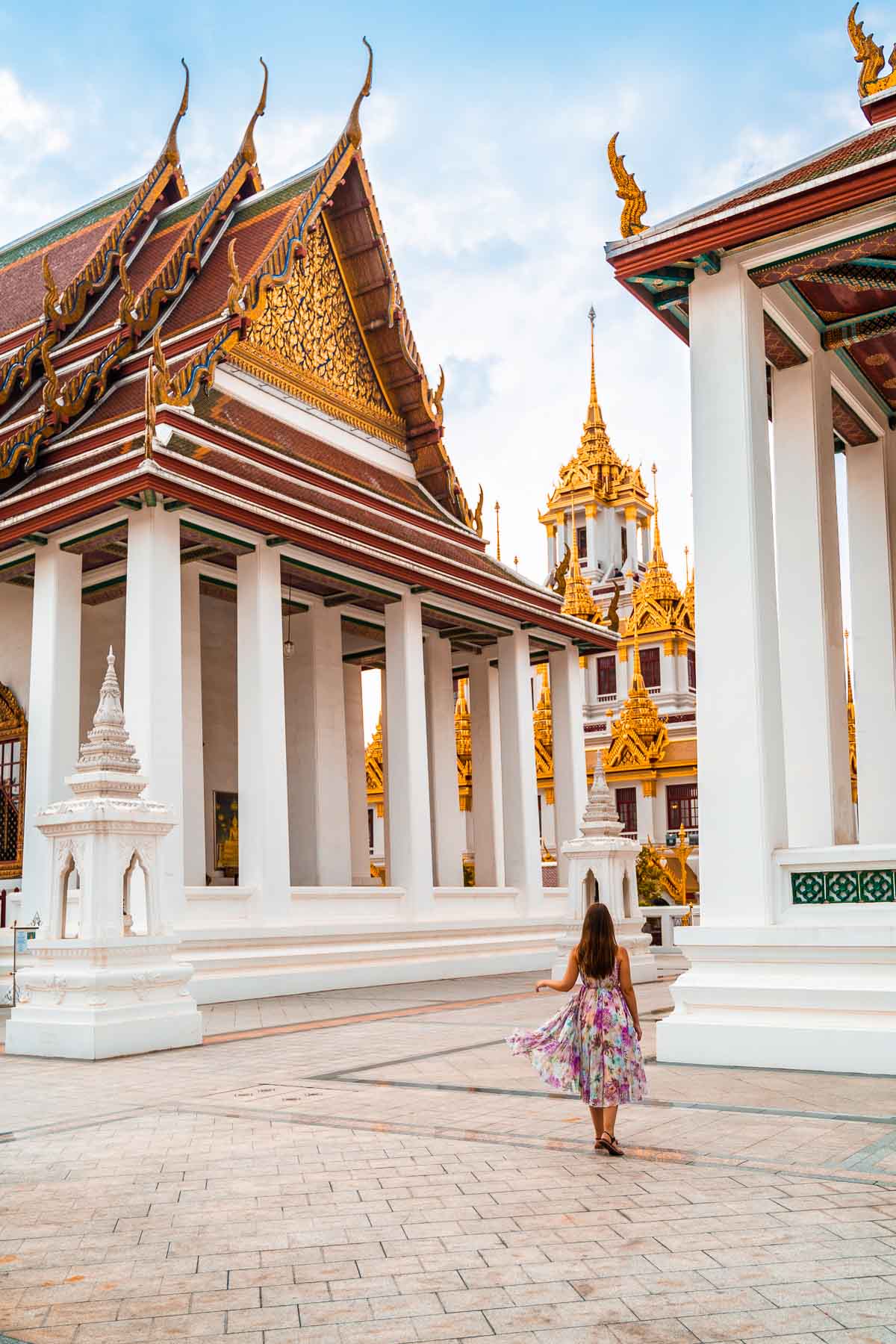 Girl in a purple dress standing in front of the Loha Prasat