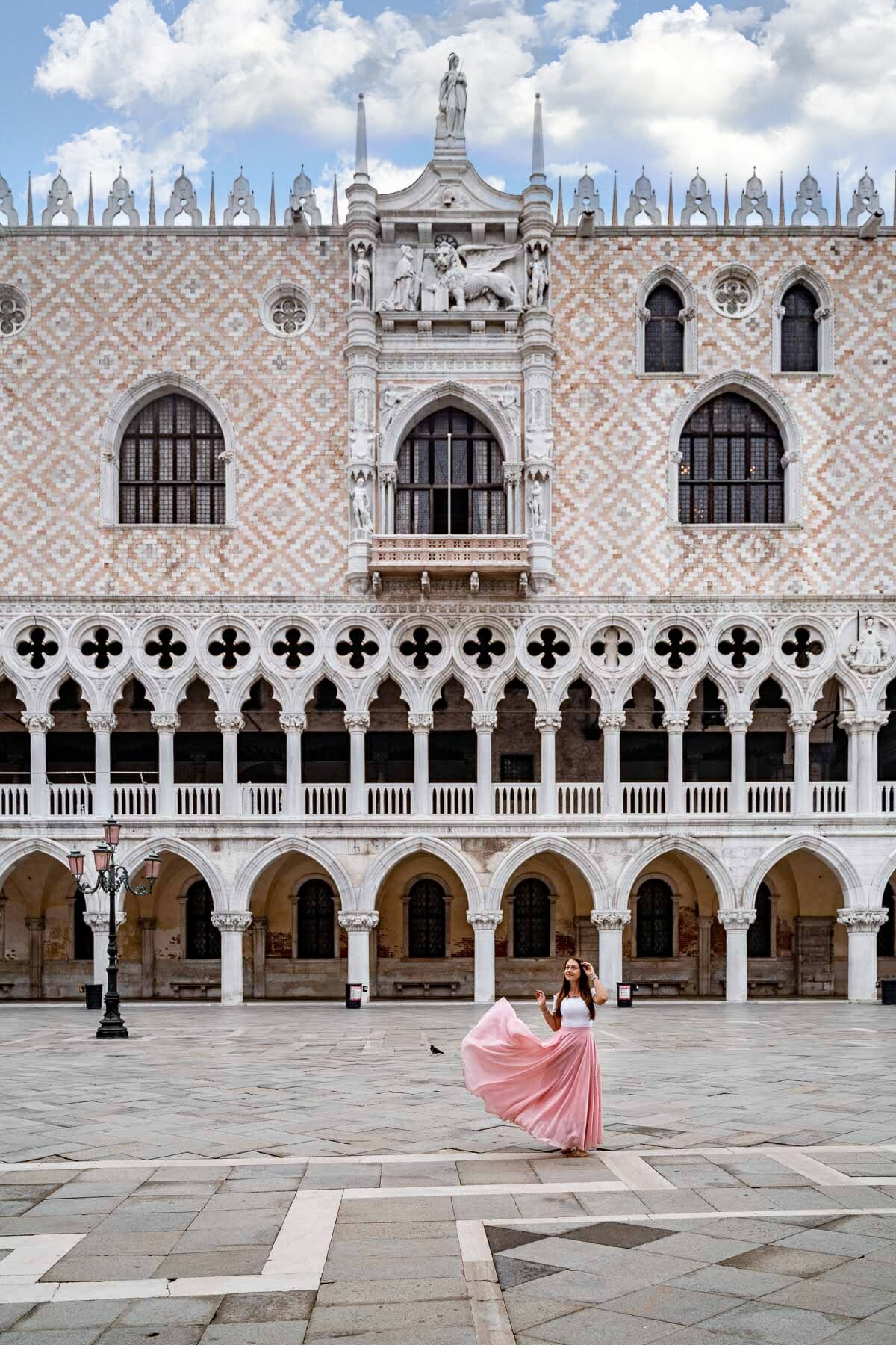 Girl in a pink skirt standing in front of Doge's Palace in Venice, Italy