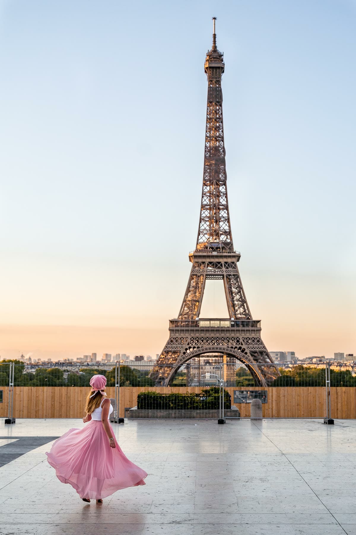 Girl in a pink skirt twirling in front of the Eiffel Tower at Trocadero, one of the most instagrammable places in Paris