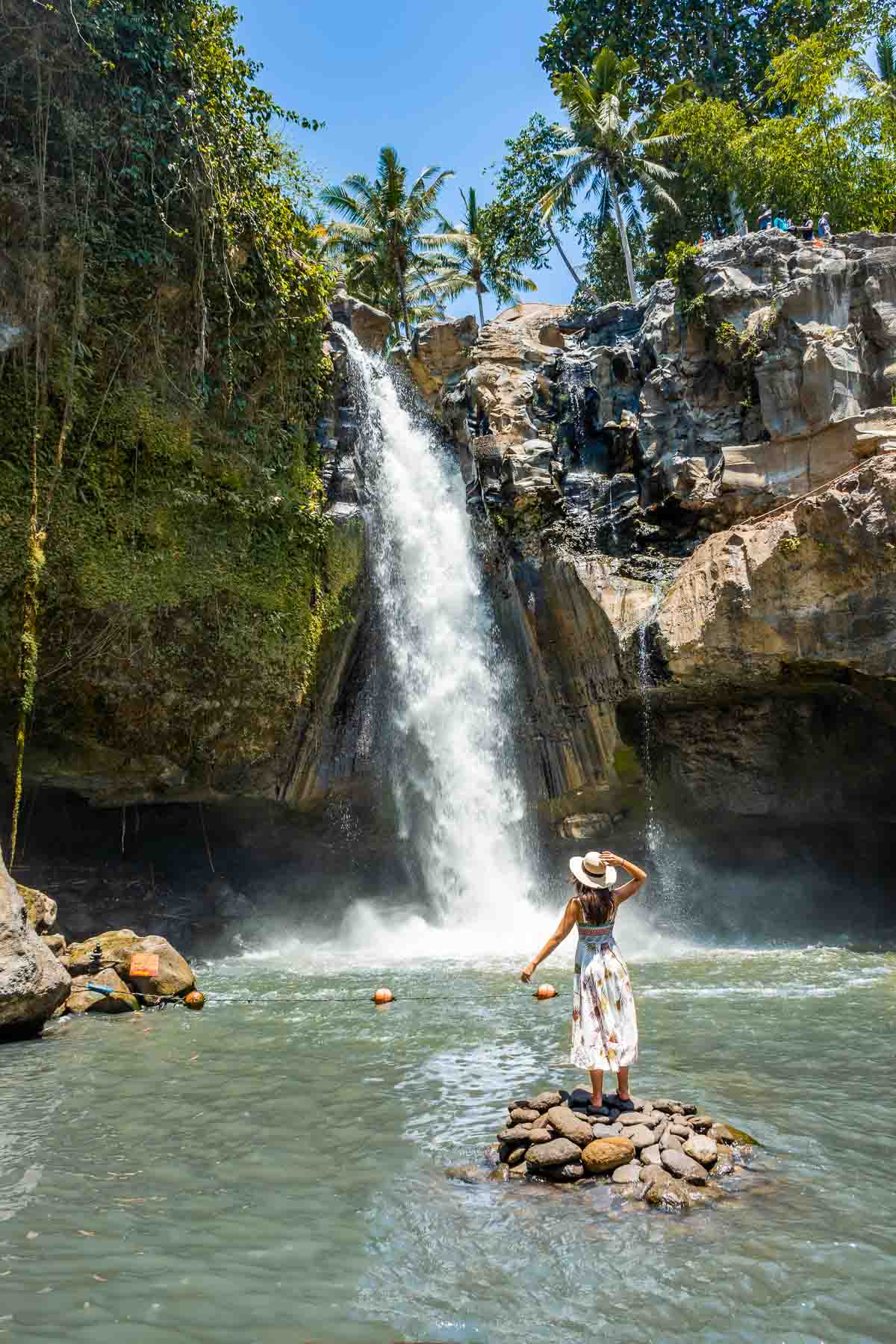 Girl standing on a rock at Tegenungan Waterfall in Bali