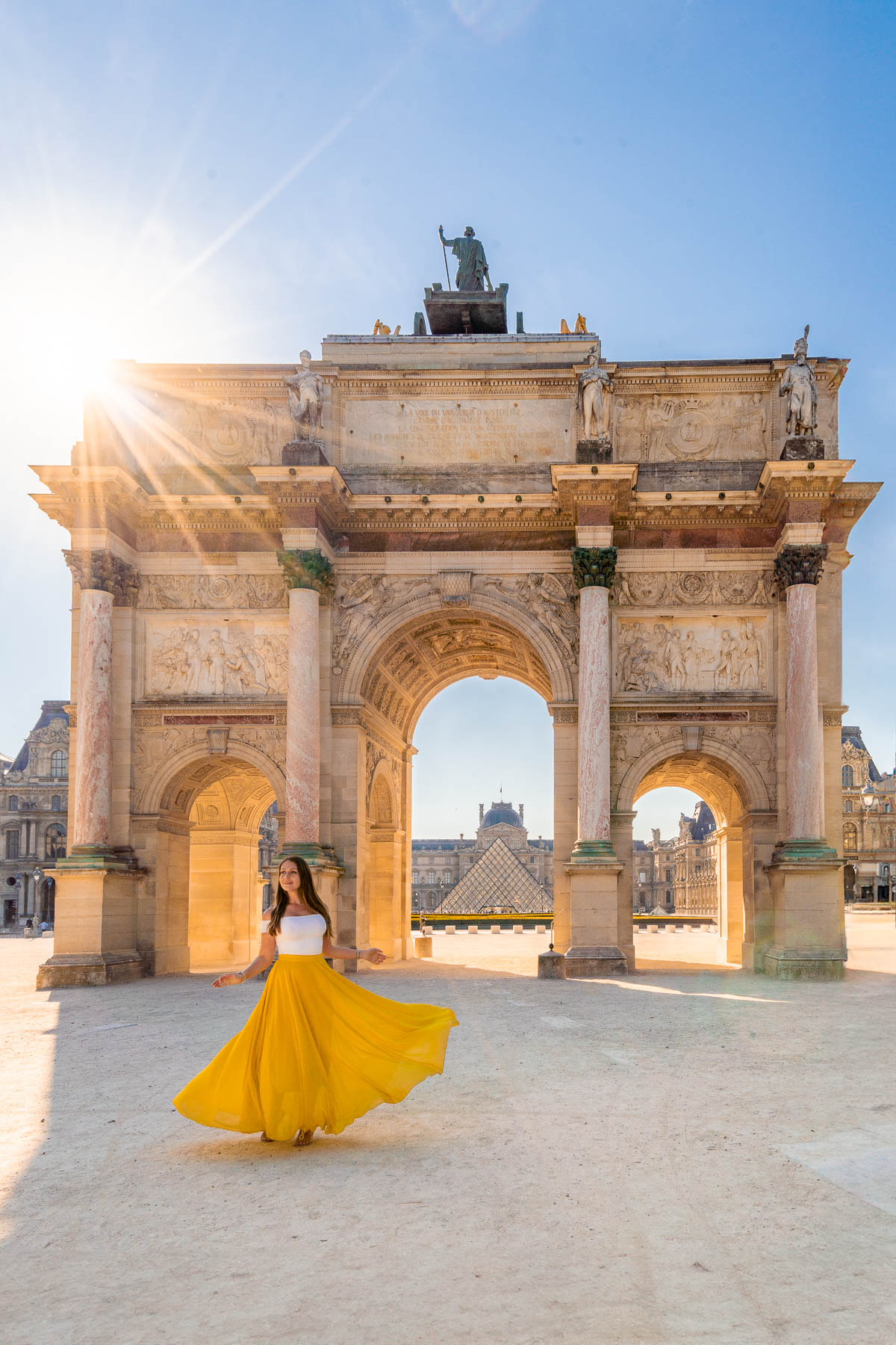 Girl in front of the Arc de Triomphe du Carrousel in Paris