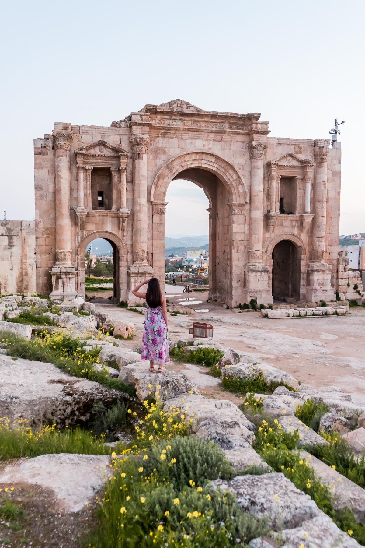 Girl in a purple floral dress standing in front of the ruins of Jerash in Jordan