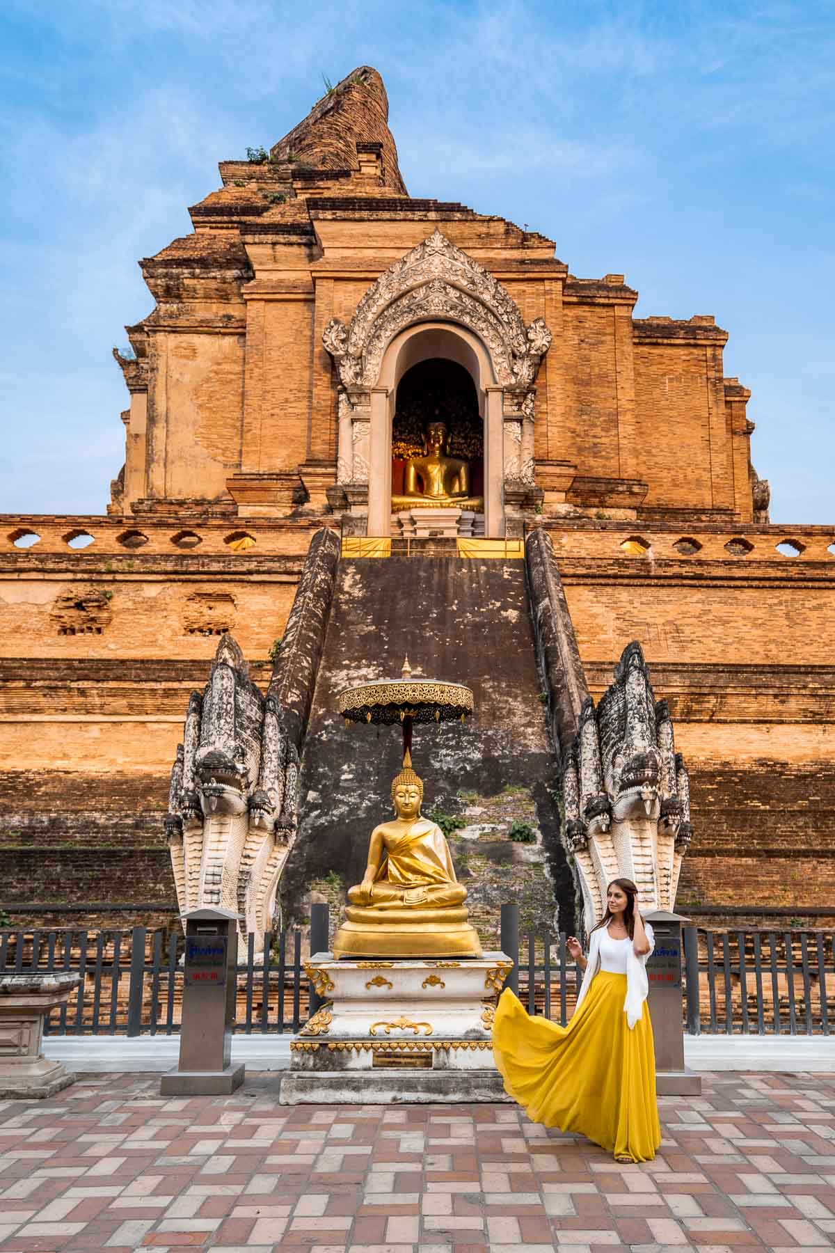 Girl in a yellow skirt in front of the Wat Chedi Luang Temple in Chiang Mai