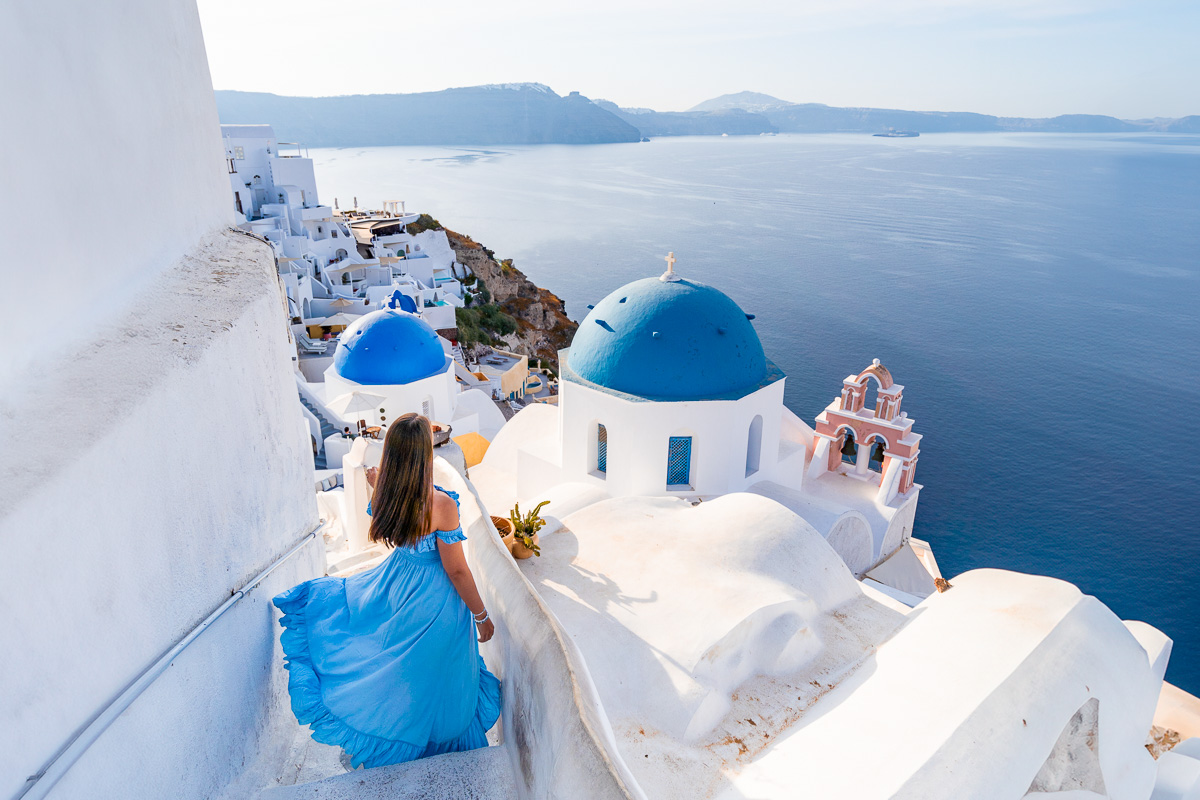 Girl in blue dress at the famous blue dome in Santorini