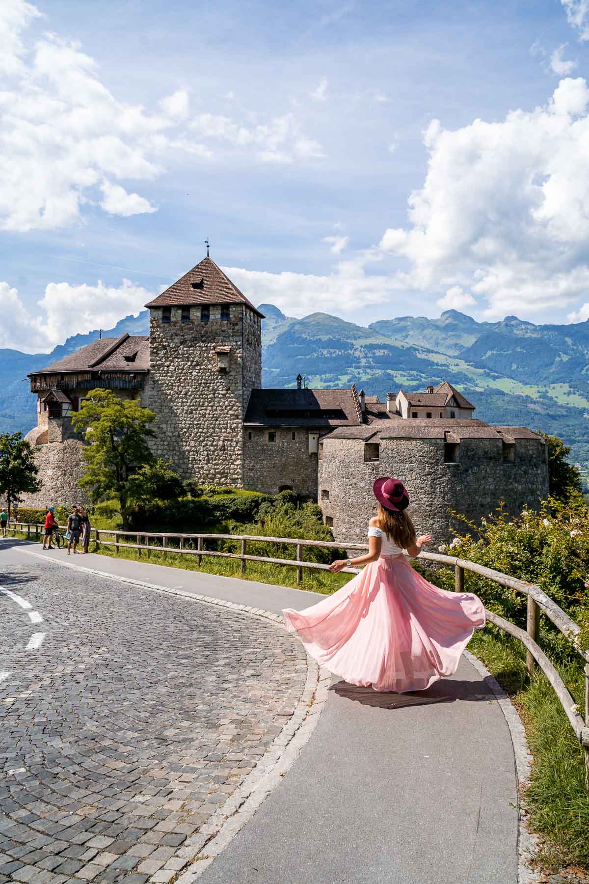 Girl in a pink skirt twirling in front of Vaduz Castle, Liechtenstein