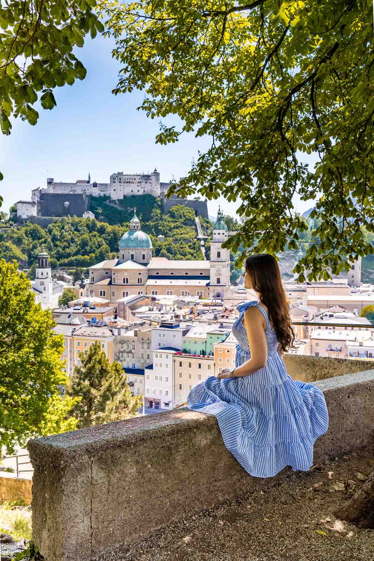 Panoramic view of Salzburg from the Kapuzinerkloster viewpoint with girl in a blue dress