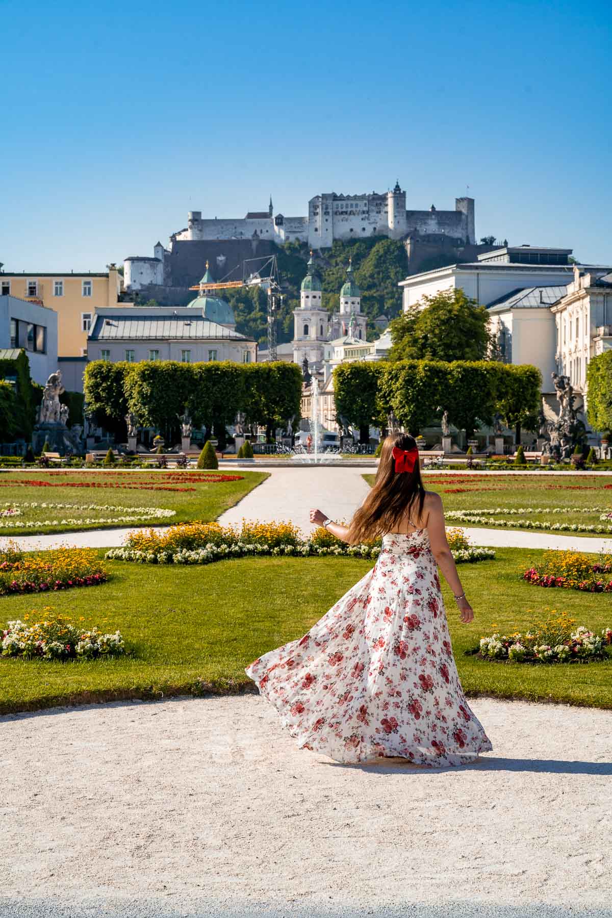 Girl in a floral dress twirling in Mirabell Gardens, Salzburg