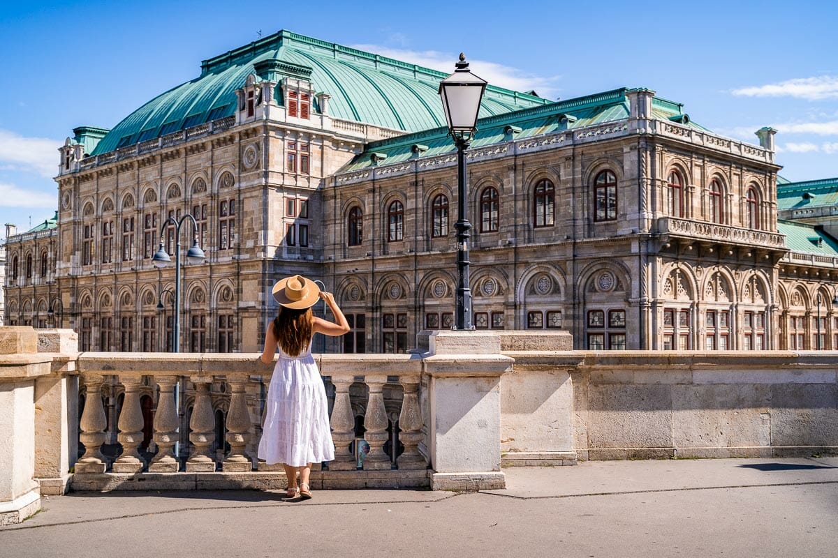Girl in a white dress in front of the Vienna State Opera