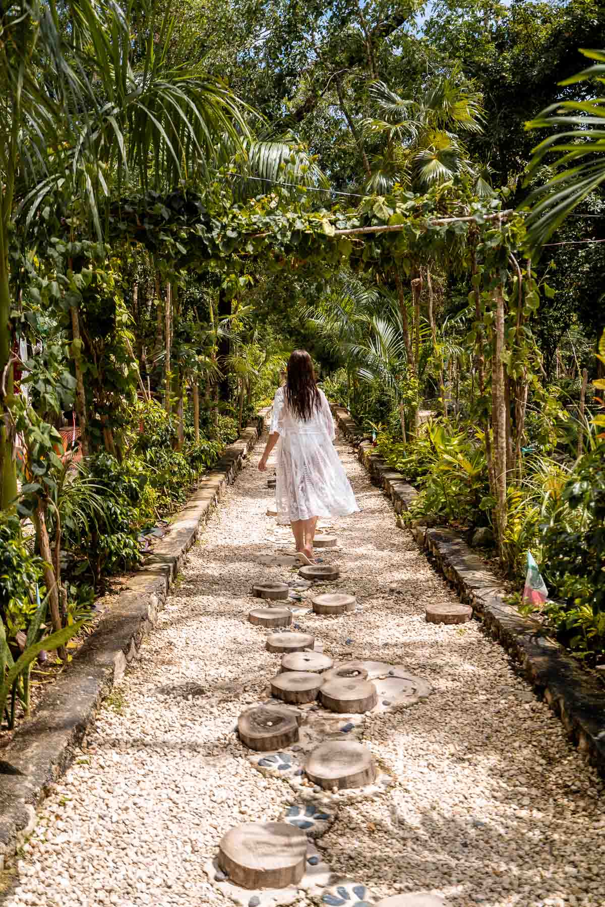 Girl in white swim coverup walking to Cenote Calavera