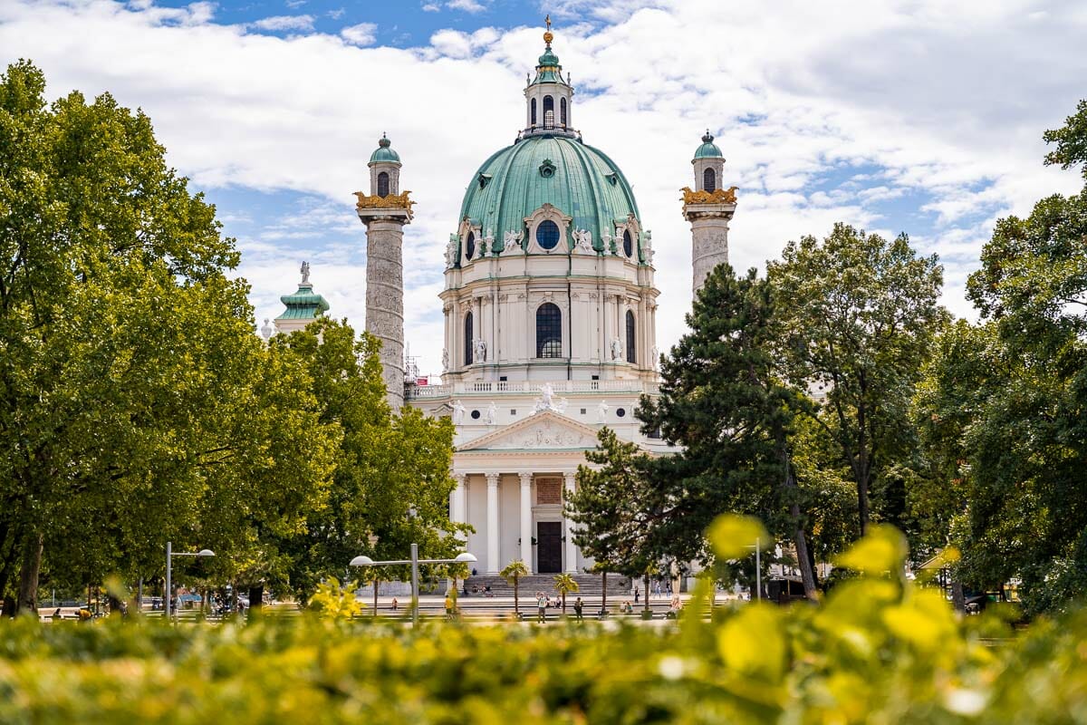 Karlskirche surrounded by green trees in Vienna, Austria