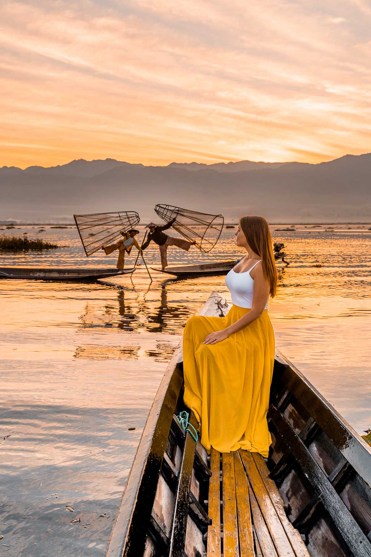 Girl sitting in a boat on Inle Lake at sunrise