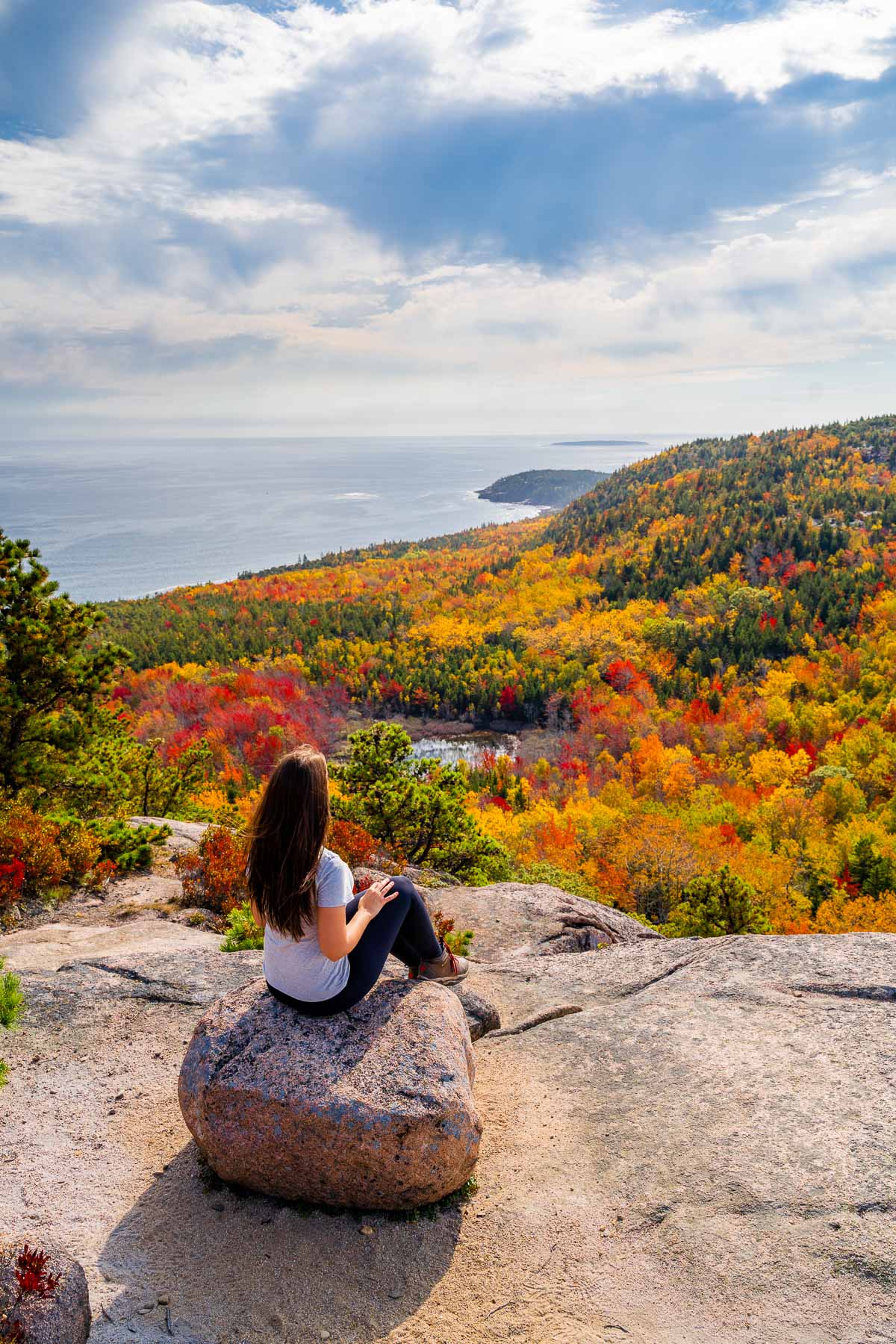 Girl at the summit of the Beehive Trail in Acadia National Park in October