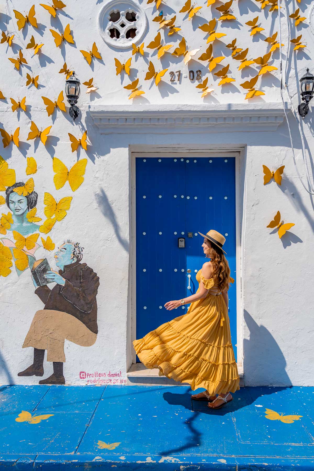 Girl in front of a blue door in Getsemani, Cartagena