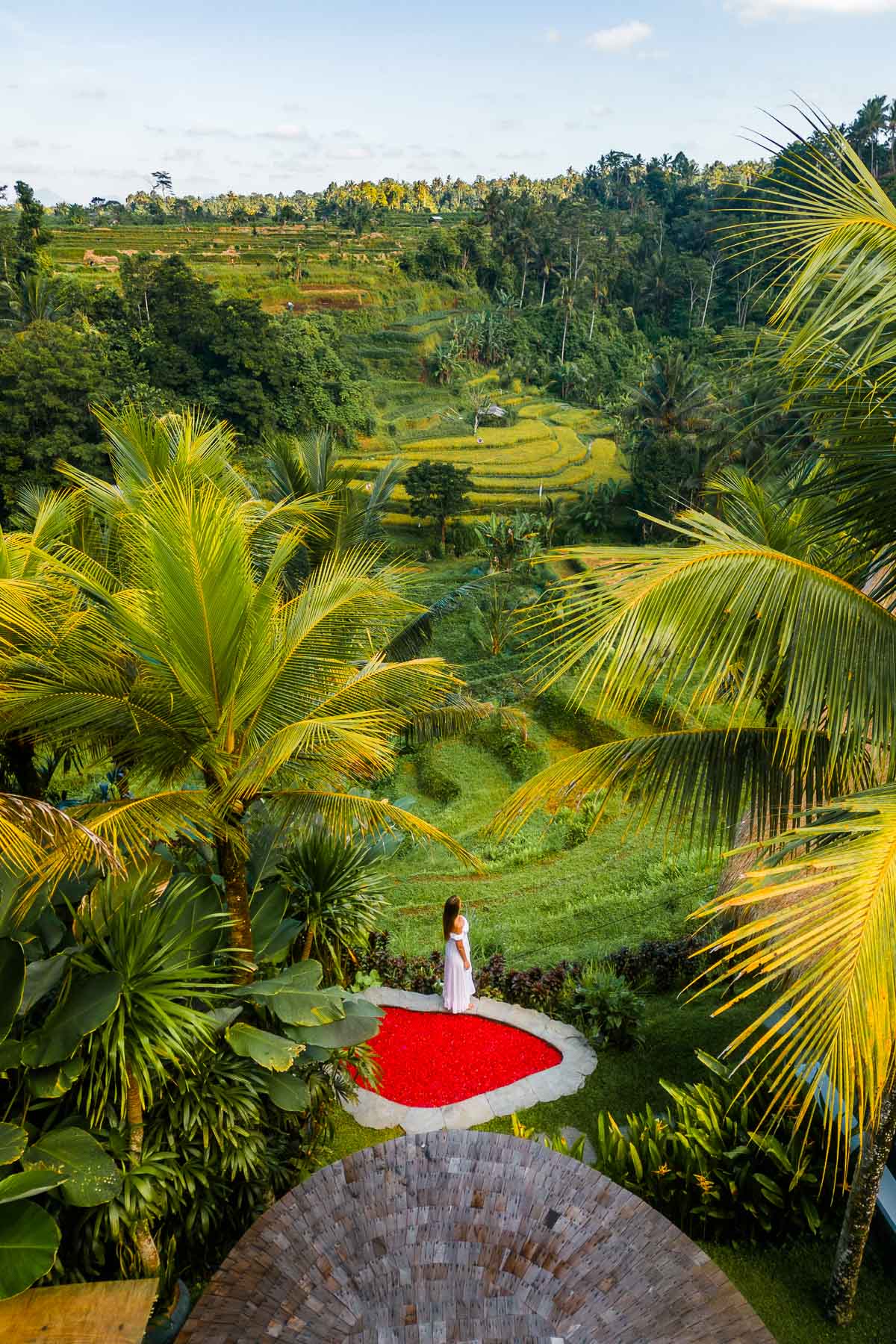 Girl by the hot tub filled with red flower petals at Camaya Bali Pyramid House