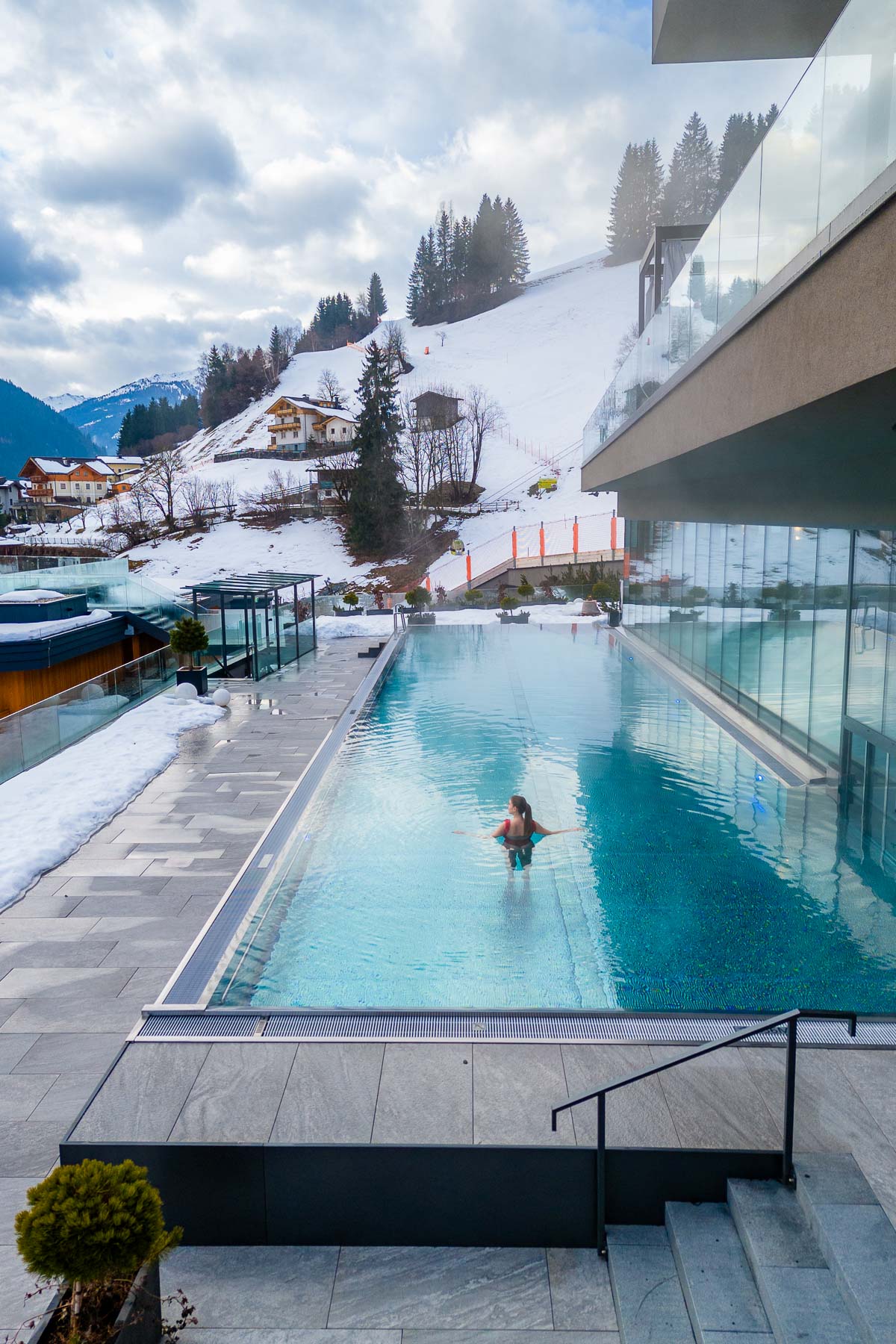 Girl in an outdoor pool at Das Edelweiss Salzburg Mountain Resort