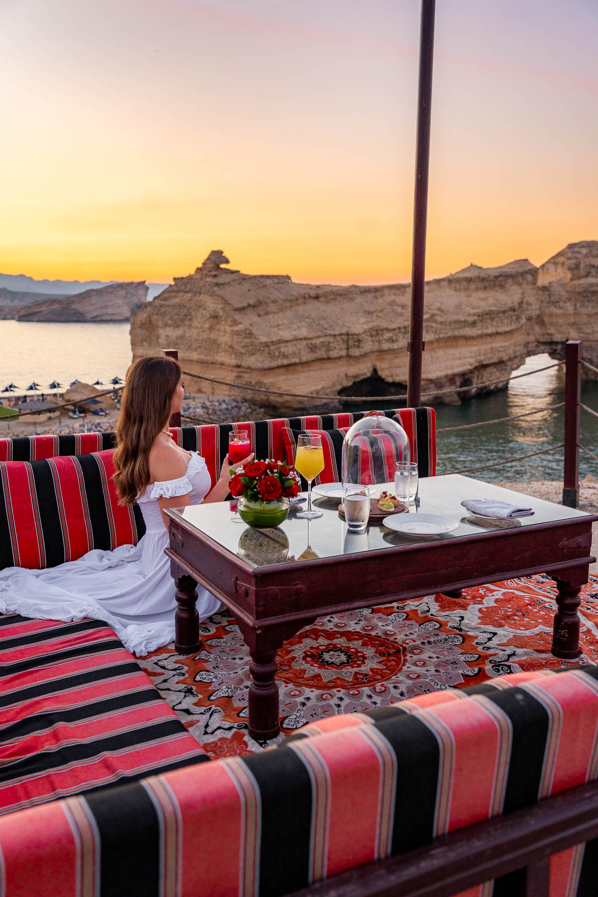 Girl watching the sunset on the clifftop at Shangri-La Al Husn