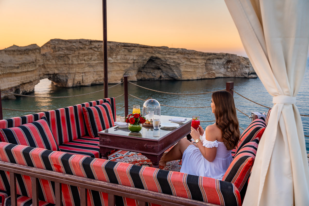 Girl watching the sunset on the clifftop at Shangri-La Al Husn