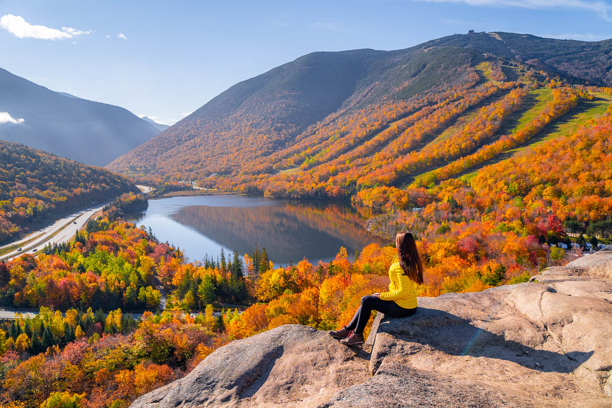 Girl sitting at the top of Artist Bluff NH in fall