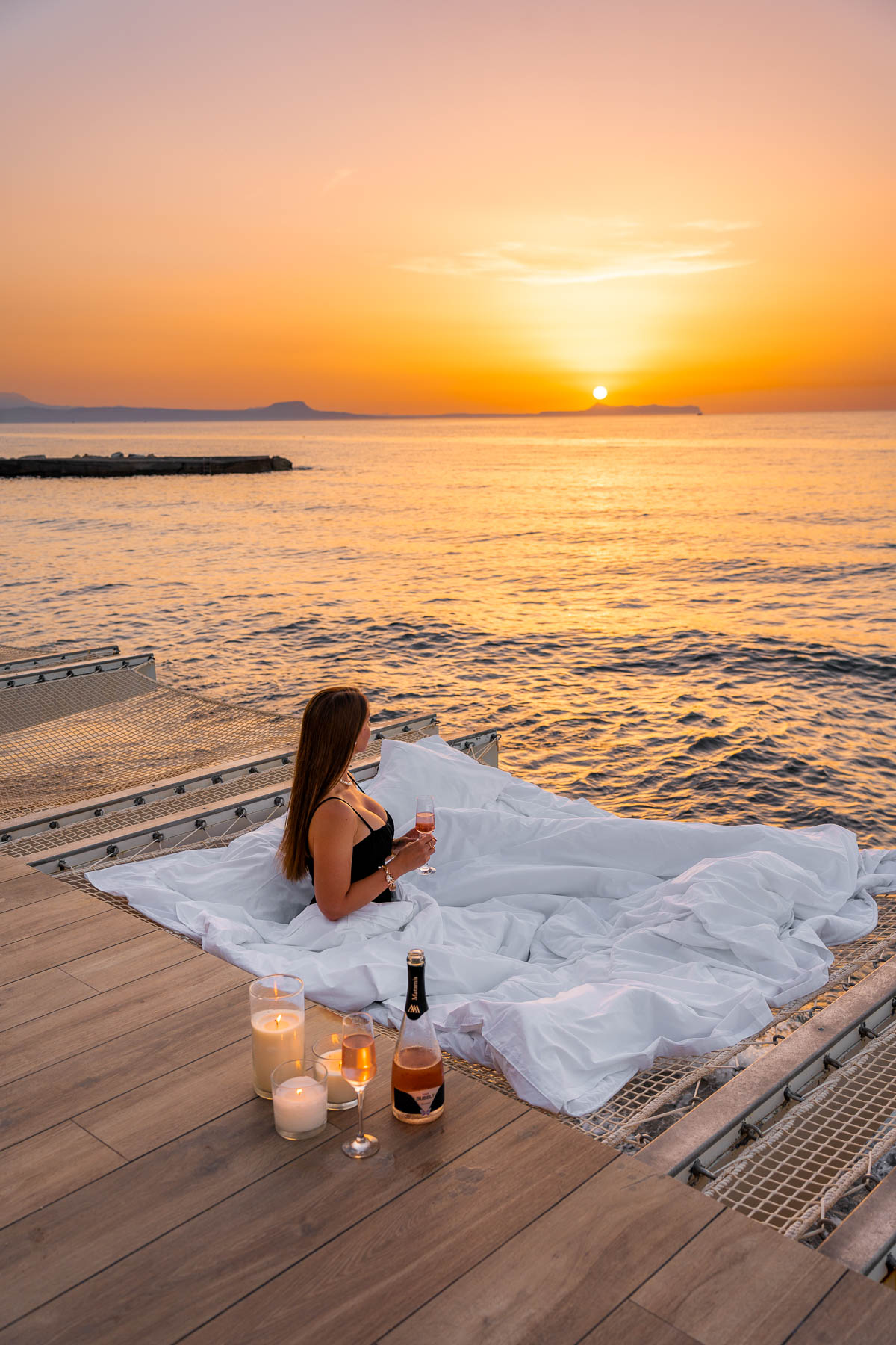 Girl watching sunset at the hanging nets at Grecotel LUXME White Palace