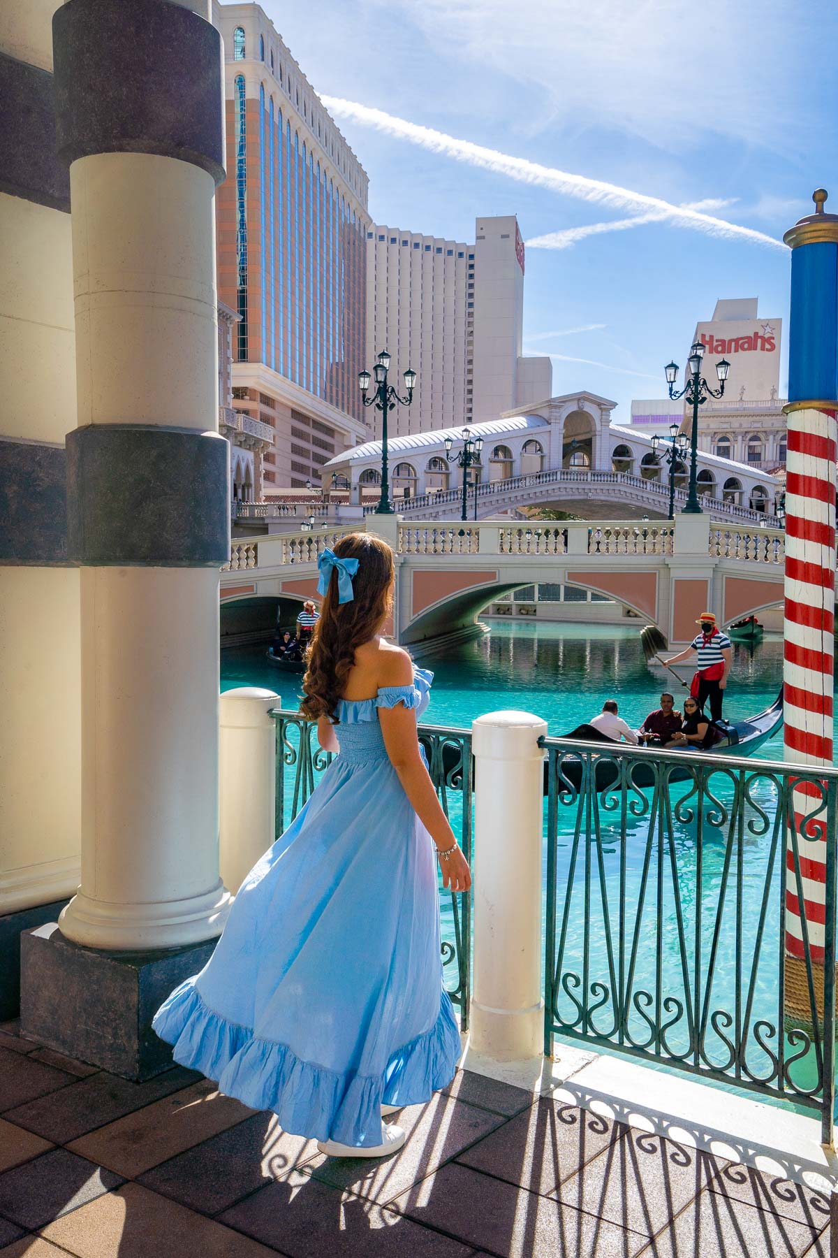 Girl in blue dress at The Venetian Las Vegas overlooking the outdoor pool with gondolas